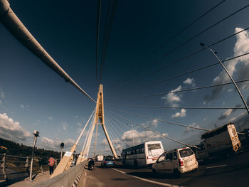 Cars on bridge against sky in city