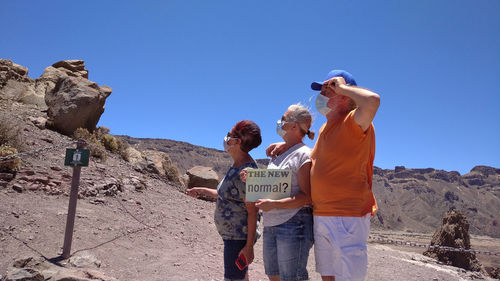 People standing on land against mountains and sky