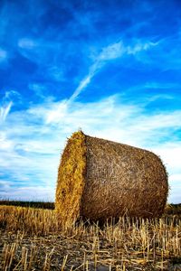 Hay bales on field against sky