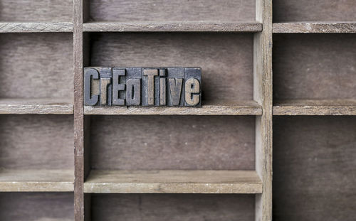 Close-up of creative text on wooden shelf