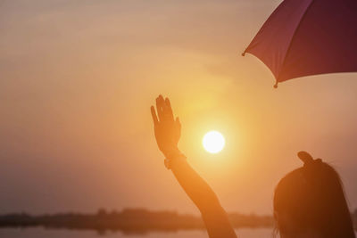 Silhouette man standing at beach during sunset