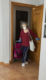 Woman standing by door at home