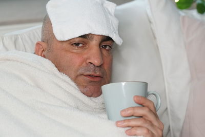 Portrait of sick man having coffee at home