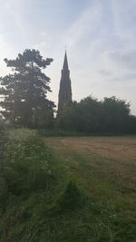 Scenic view of trees and building against sky