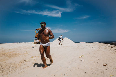 Rear view of shirtless man on beach