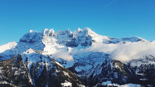 Scenic view of snowcapped mountains against clear blue sky