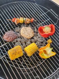 Close-up of burgers, bell peppers, shrimp kebab on grill