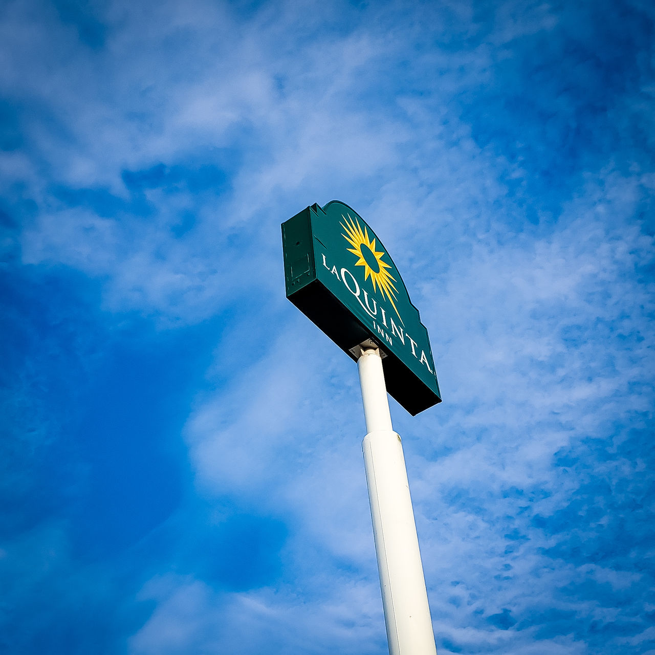 low angle view, cloud - sky, sky, blue, sign, day, nature, pole, no people, guidance, communication, outdoors, text, information, symbol, road sign, western script, direction, directional sign, lighting equipment