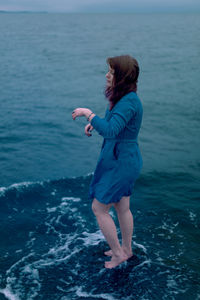 Rear view of woman standing in sea