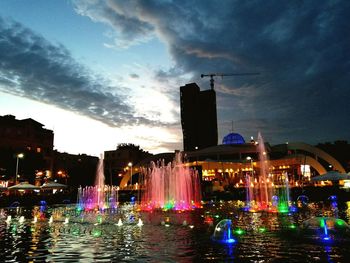 Illuminated buildings by swimming pool at night