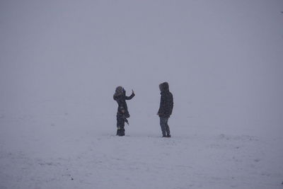 Rear view of women on snow covered land