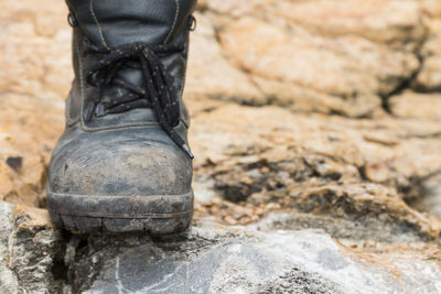 Low section person wearing shoes on rock