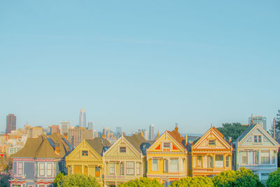 Buildings in city against clear blue sky