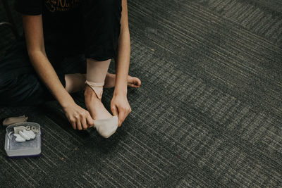 Young girl putting on her ballet shoes