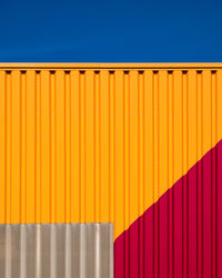 Multi colored cargo container against blue sky