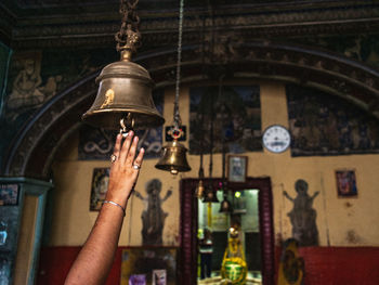 Low angle view of woman hand ringing a bell in the temple