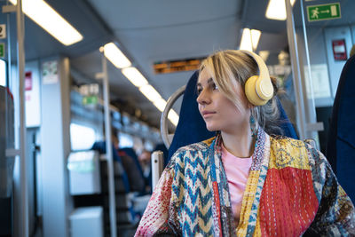 Woman with wireless headphones traveling in train