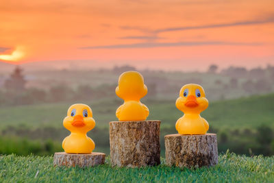 Close-up of yellow toys on field during sunset