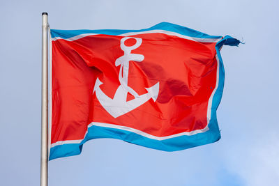 Low angle view of flag against blue sky