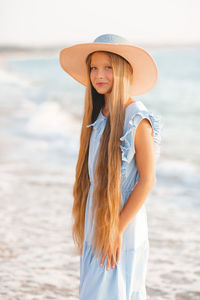 Beautiful smiling blonde teenager girl 12-14 year old wear straw hat and stylish elegant dress 