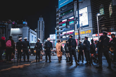 People walking on street in city during rainy season