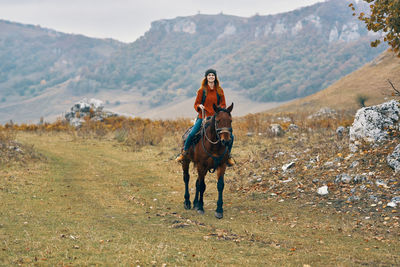 Woman riding horse on land