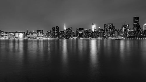 Illuminated buildings in city against sky at night