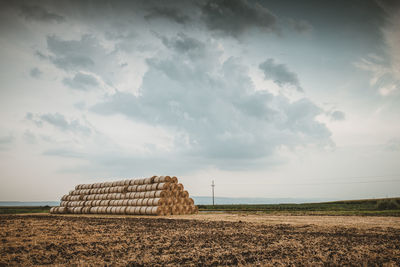 Hay bales on field against sky