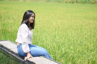 Young woman sitting on field