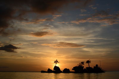 Silhouette ship in sea against sky during sunset