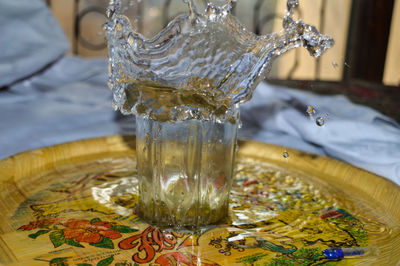 Close-up of water splashing in glass on table