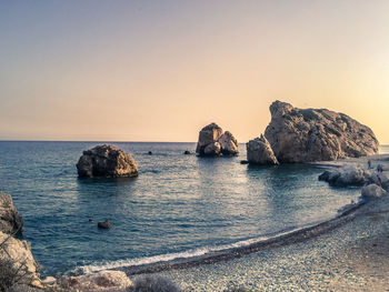 Scenic view of rocks in sea against clear sky