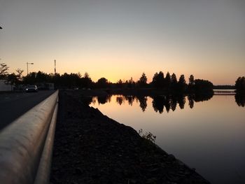 Scenic view of lake against clear sky during sunset