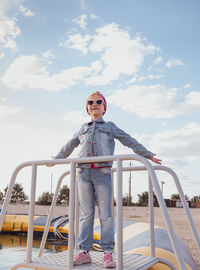 Little girl raised arms blue sky. happy child smiling flying in the air. lifestyle freedom happiness