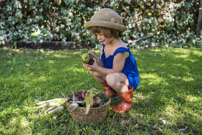 Full length of girl holding basket in grass