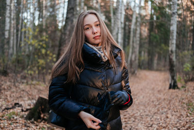 Portrait of young woman standing in forest