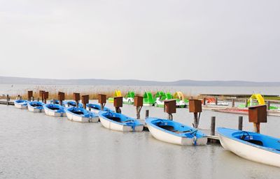 Boats moored in sea against clear sky