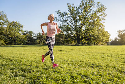 Senior woman running on rural meadow