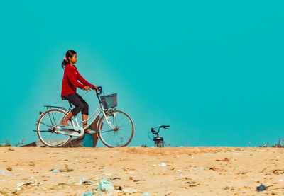 Side view of man riding bicycle on land