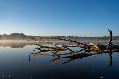 Scenic view of lake against clear blue sky