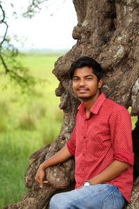 Portrait of young man sitting on rock