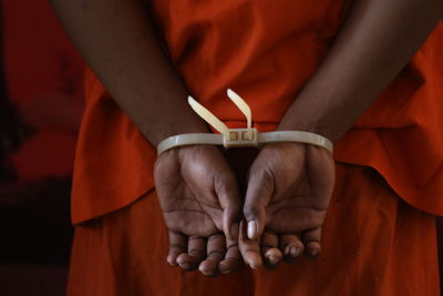 Close-up of man holding hands while standing outdoors