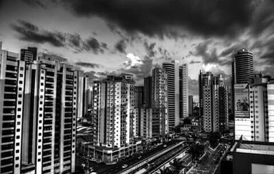 View of cityscape against cloudy sky