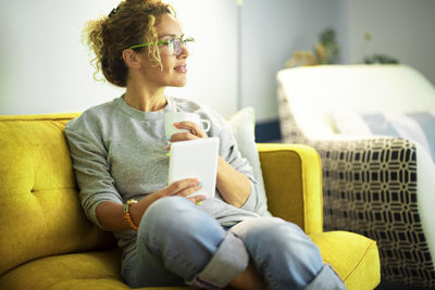 Man using mobile phone while sitting on sofa at home