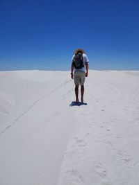 Full length rear view of man on desert against sky