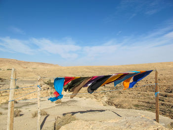 Clothes drying on beach against blue sky