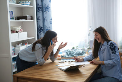 Two women communicate by telephone with the customer, agree on the order in the light handmade