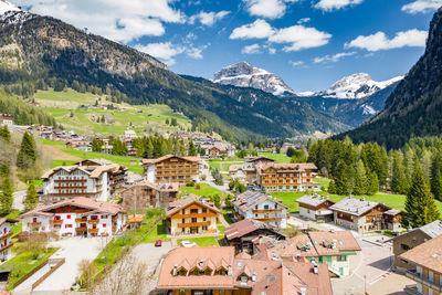 Houses in town by mountains against sky