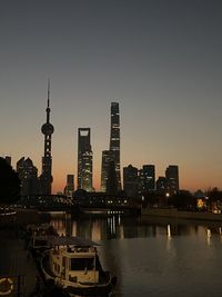 Illuminated buildings in city against clear sky