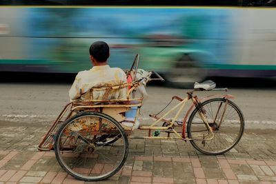 Rear view of man sitting on pedicab